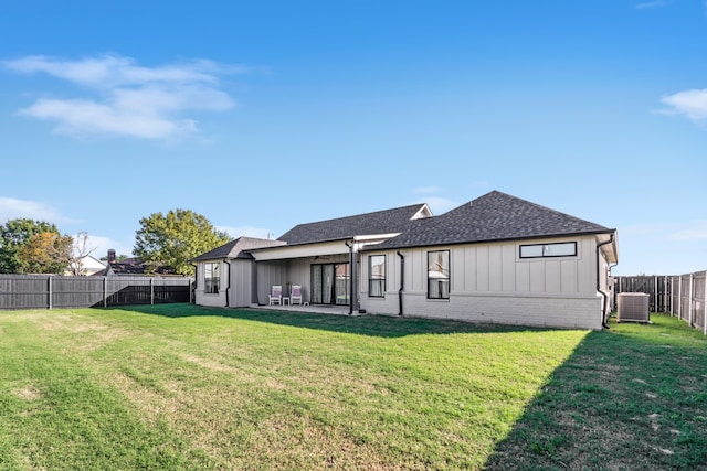 rear view of house featuring cooling unit, a lawn, and a patio