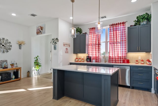 kitchen featuring sink, stainless steel dishwasher, light hardwood / wood-style floors, and a kitchen island