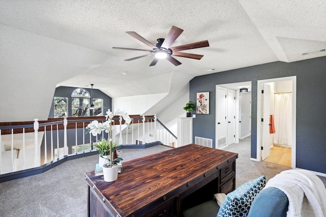 office area featuring light carpet, lofted ceiling, and a textured ceiling