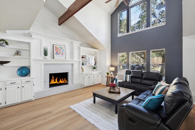 living room featuring high vaulted ceiling, beamed ceiling, a healthy amount of sunlight, and light wood-type flooring