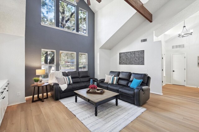 living room featuring high vaulted ceiling, light wood-type flooring, and a wealth of natural light