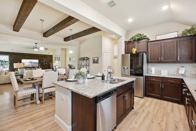 kitchen featuring pendant lighting, sink, a kitchen island with sink, stainless steel appliances, and light stone countertops