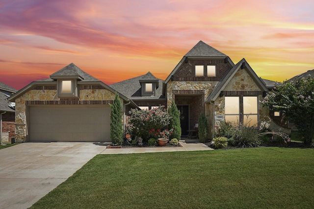 view of front facade with stone siding, driveway, an attached garage, and a front lawn