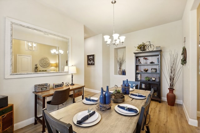 dining space featuring light hardwood / wood-style floors and an inviting chandelier