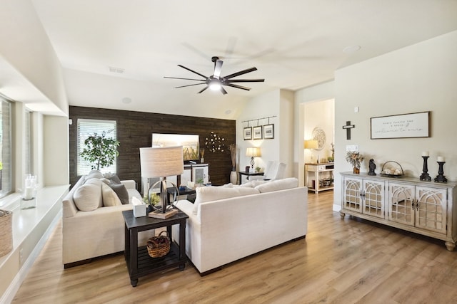 living room featuring vaulted ceiling, light hardwood / wood-style flooring, and ceiling fan