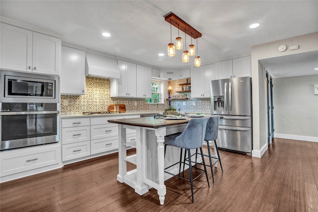 kitchen featuring dark wood-style floors, premium range hood, open shelves, white cabinets, and appliances with stainless steel finishes