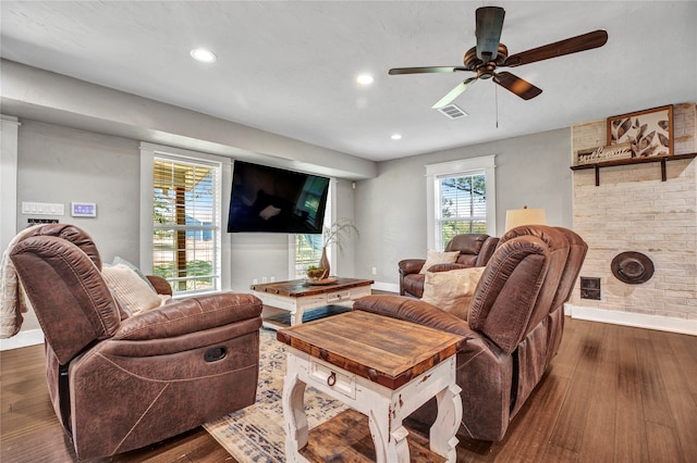 living room with dark wood-style floors, visible vents, and baseboards