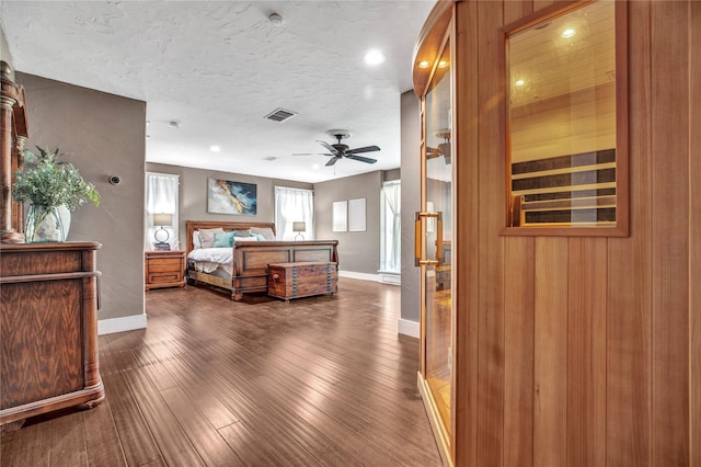 bedroom featuring visible vents, baseboards, dark wood-type flooring, and a textured ceiling