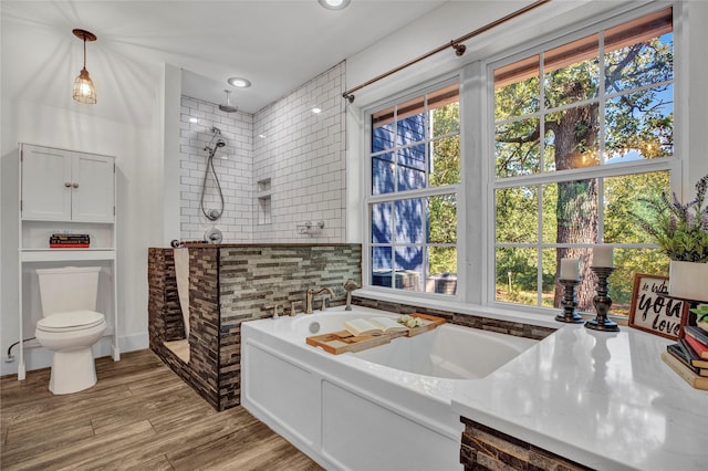 bathroom with recessed lighting, a garden tub, walk in shower, and wood finished floors