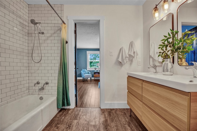 bathroom featuring baseboards, wood finished floors, double vanity, shower / bathtub combination with curtain, and a sink