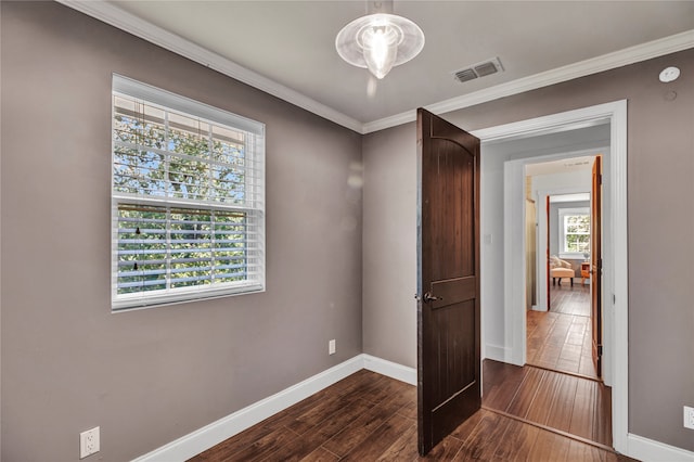 interior space featuring visible vents, crown molding, dark wood-type flooring, and baseboards