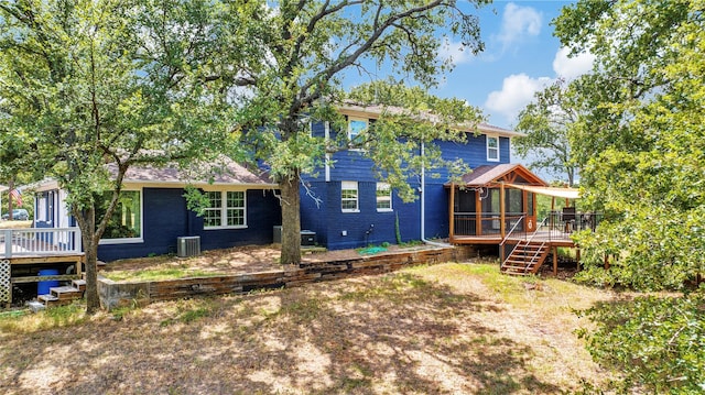 back of house featuring stairway, a wooden deck, central AC, and a sunroom