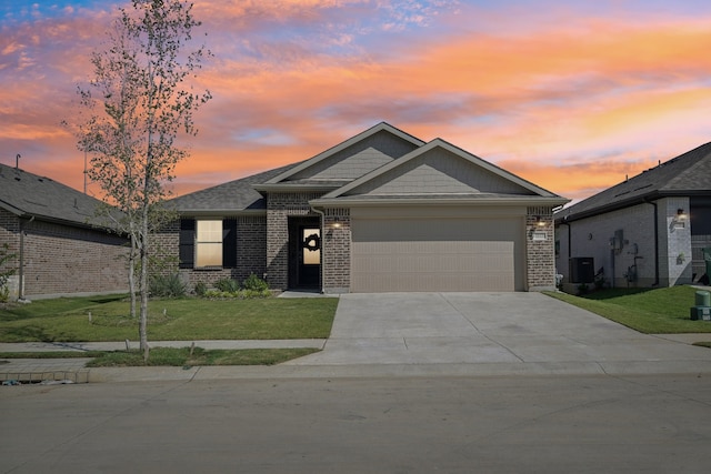 view of front facade with a garage, a lawn, and central air condition unit