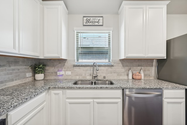 kitchen featuring backsplash, white cabinetry, sink, and stainless steel dishwasher