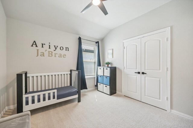 carpeted bedroom with ceiling fan, vaulted ceiling, and a closet