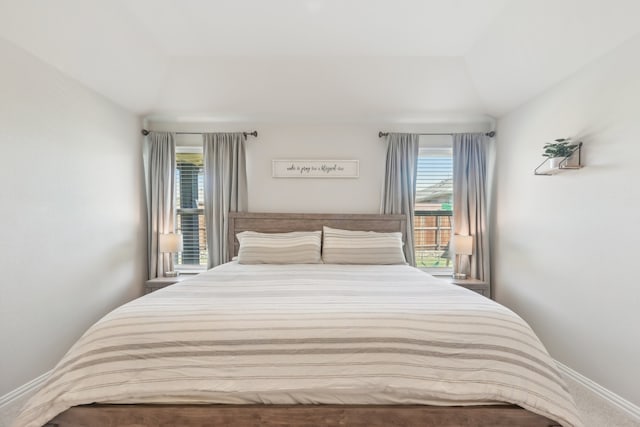 carpeted bedroom with lofted ceiling