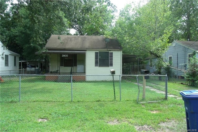 rear view of house with a lawn and a carport