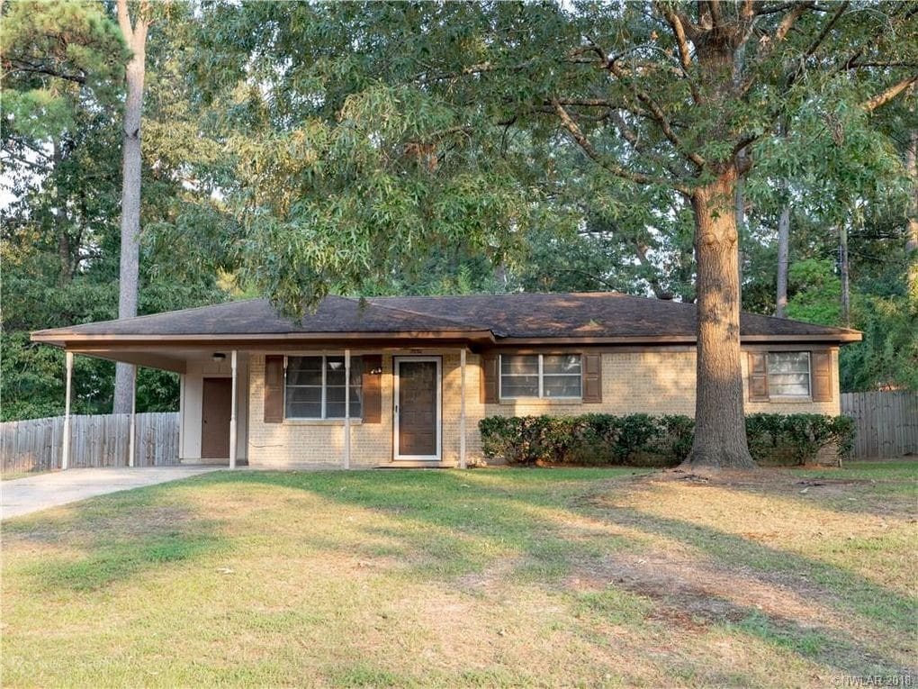 view of front of property featuring a front yard and a carport