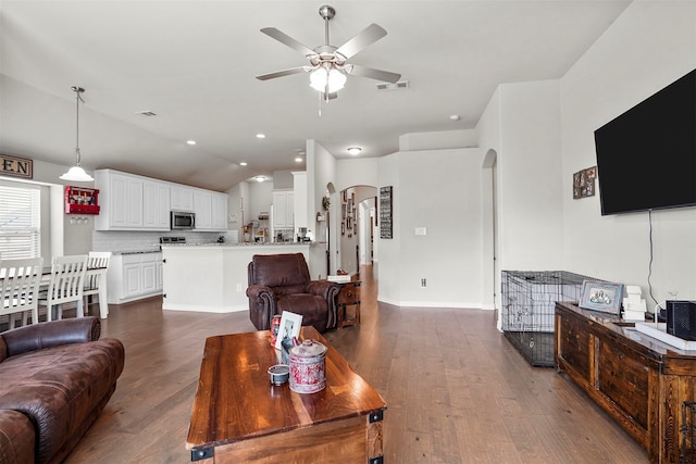 living room featuring ceiling fan, dark hardwood / wood-style flooring, and vaulted ceiling