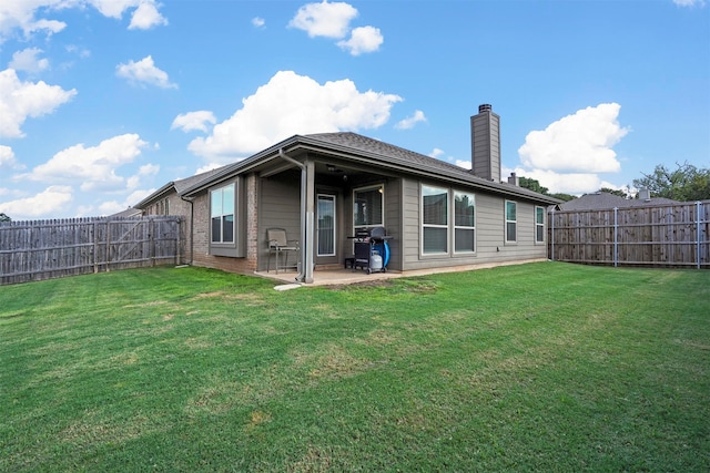 back of house featuring a lawn and a patio area