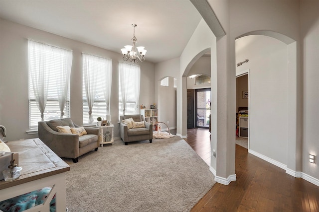 living room with a chandelier, plenty of natural light, and dark wood-type flooring