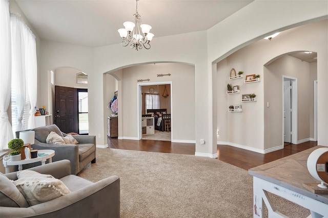 living room with dark hardwood / wood-style flooring and a notable chandelier