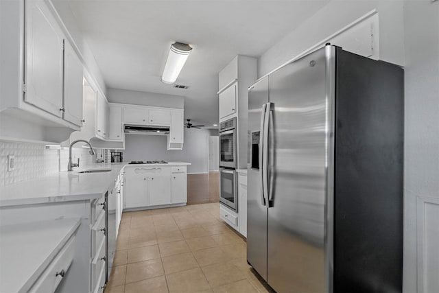 kitchen with backsplash, white cabinetry, sink, and stainless steel appliances