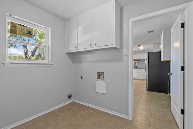 laundry area featuring hookup for a washing machine, light tile patterned floors, cabinets, and hookup for an electric dryer