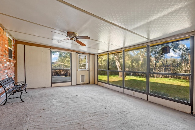 unfurnished sunroom featuring ceiling fan