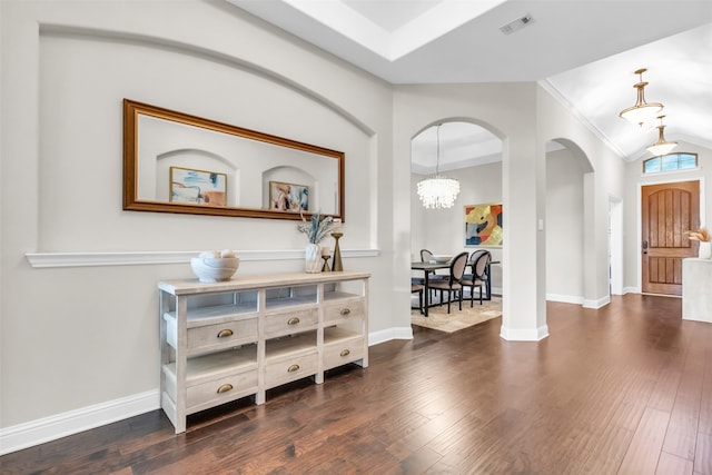 entryway with crown molding, dark hardwood / wood-style floors, and a chandelier