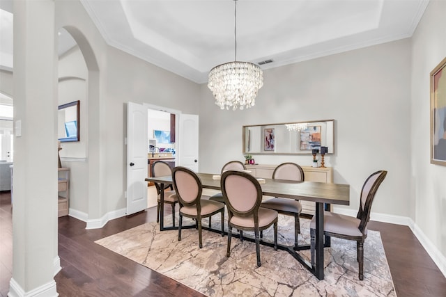 dining room featuring a chandelier, ornamental molding, dark hardwood / wood-style floors, and a raised ceiling