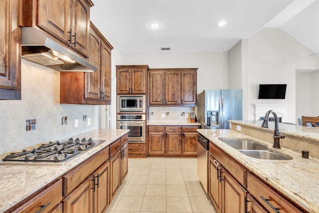 kitchen with sink, light tile patterned floors, appliances with stainless steel finishes, light stone counters, and tasteful backsplash