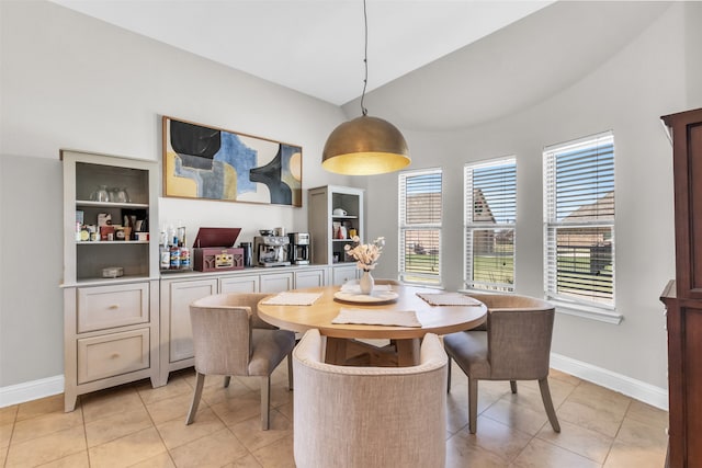 tiled dining room with vaulted ceiling