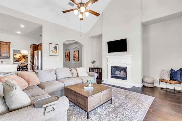 living room with ceiling fan, dark hardwood / wood-style floors, and high vaulted ceiling