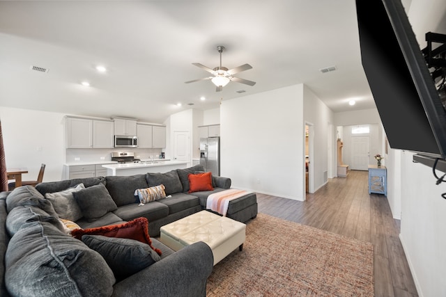 living room featuring ceiling fan and light hardwood / wood-style flooring