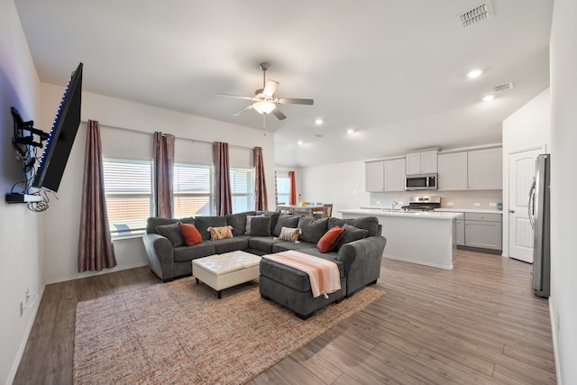 living room featuring ceiling fan and light hardwood / wood-style flooring