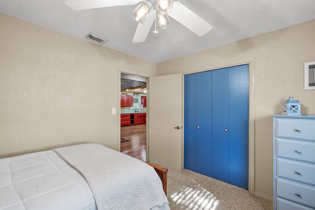 carpeted bedroom with a closet and ceiling fan