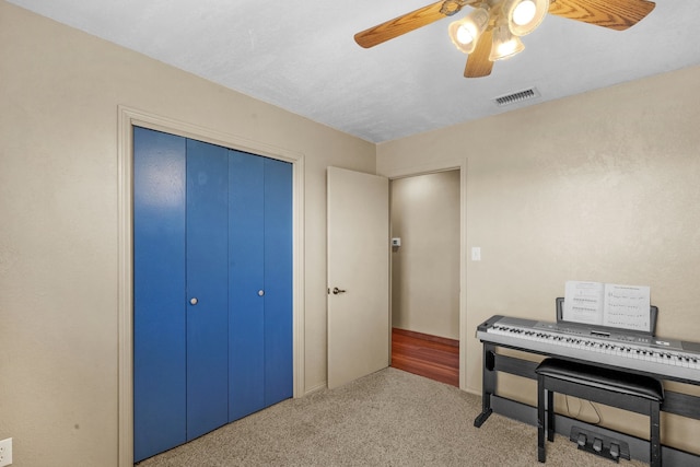 miscellaneous room with ceiling fan and light colored carpet