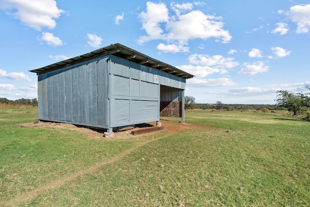 view of outbuilding with a lawn and a rural view