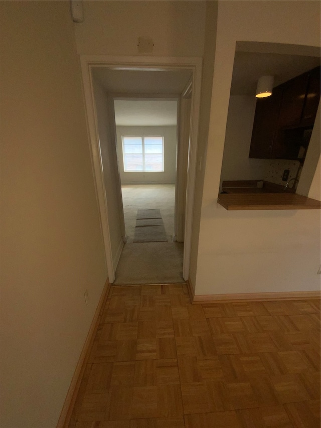 hallway featuring parquet flooring