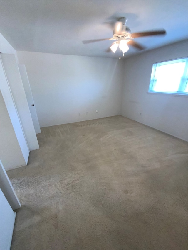 carpeted spare room with ceiling fan