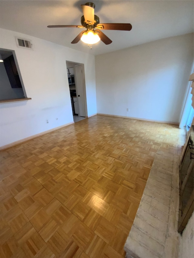 unfurnished room with ceiling fan and light parquet flooring