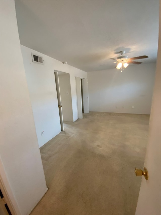 carpeted empty room featuring ceiling fan