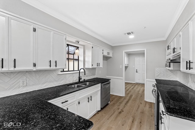 kitchen with appliances with stainless steel finishes, tasteful backsplash, sink, white cabinets, and light hardwood / wood-style floors