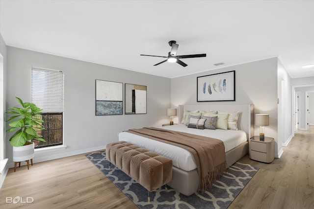 bedroom featuring ceiling fan, ornamental molding, and light wood-type flooring