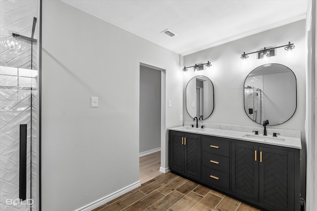 bathroom with a shower, hardwood / wood-style floors, and vanity