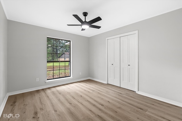 unfurnished bedroom featuring ceiling fan, light wood-type flooring, and a closet