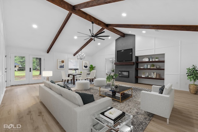 living room featuring a large fireplace, beamed ceiling, high vaulted ceiling, ceiling fan with notable chandelier, and light wood-type flooring