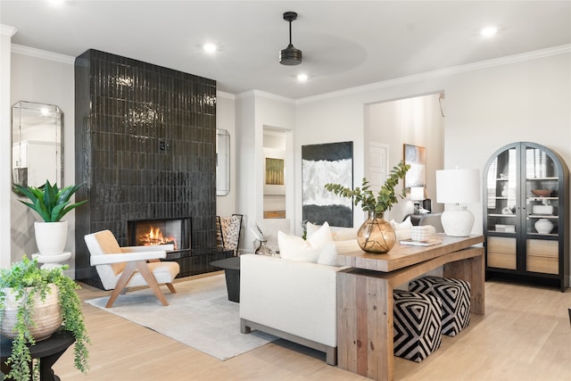 interior space with a fireplace, light hardwood / wood-style flooring, and ornamental molding