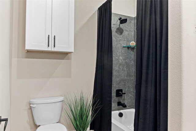 bathroom with toilet and shower / tub combo with curtain